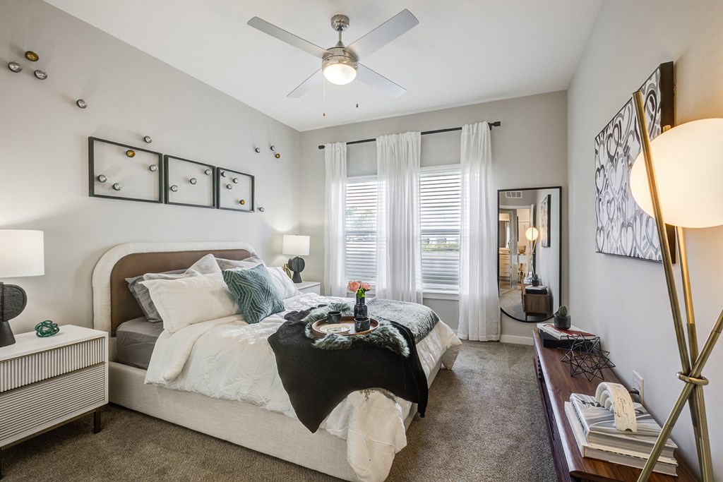 a bedroom with a large bed and a ceiling fan