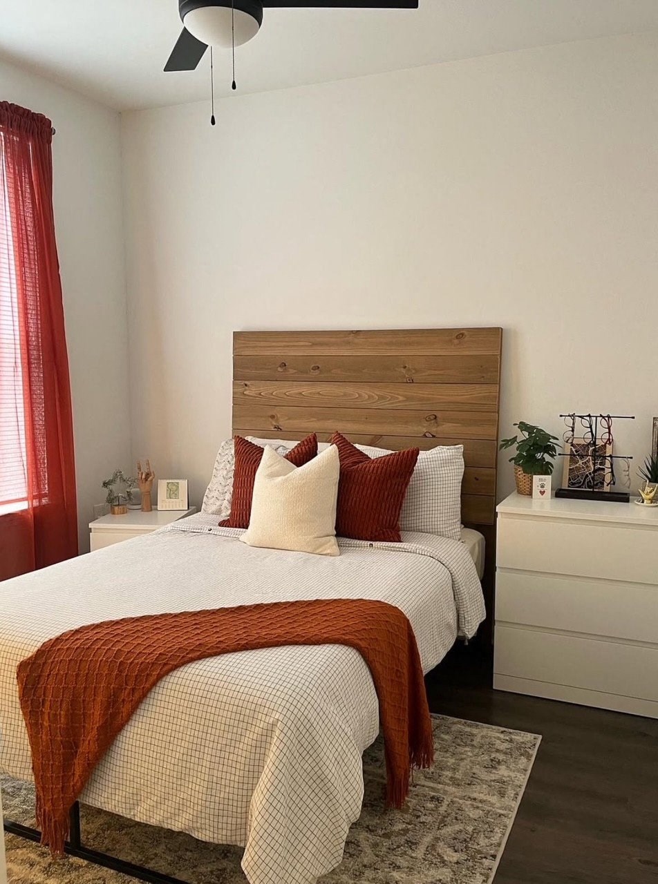 A bedroom with a bed, a dresser, and a ceiling fan.