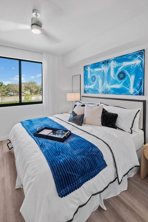 a bedroom with a white bed and a blue blanket