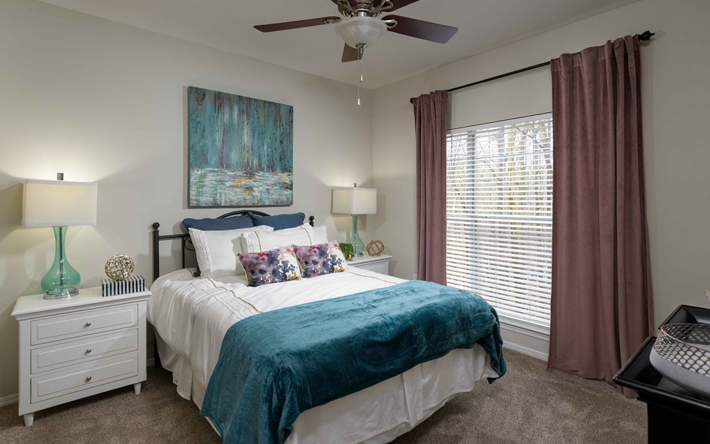 a bedroom with a bed and a ceiling fan
