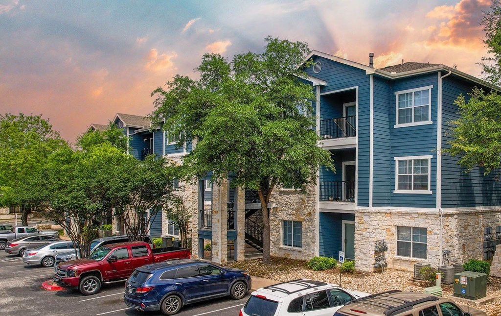 an apartment building with cars parked in front of it