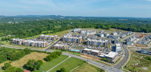 A bird's eye view of a large, modern residential complex surrounded by greenery.