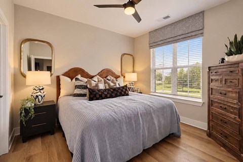 A bedroom with a bed, dresser, and mirror.