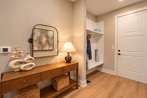 A hallway with a wooden bench and a lamp on it.