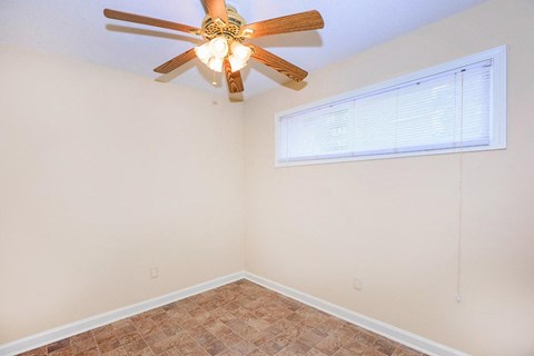 a bedroom with a ceiling fan and a window