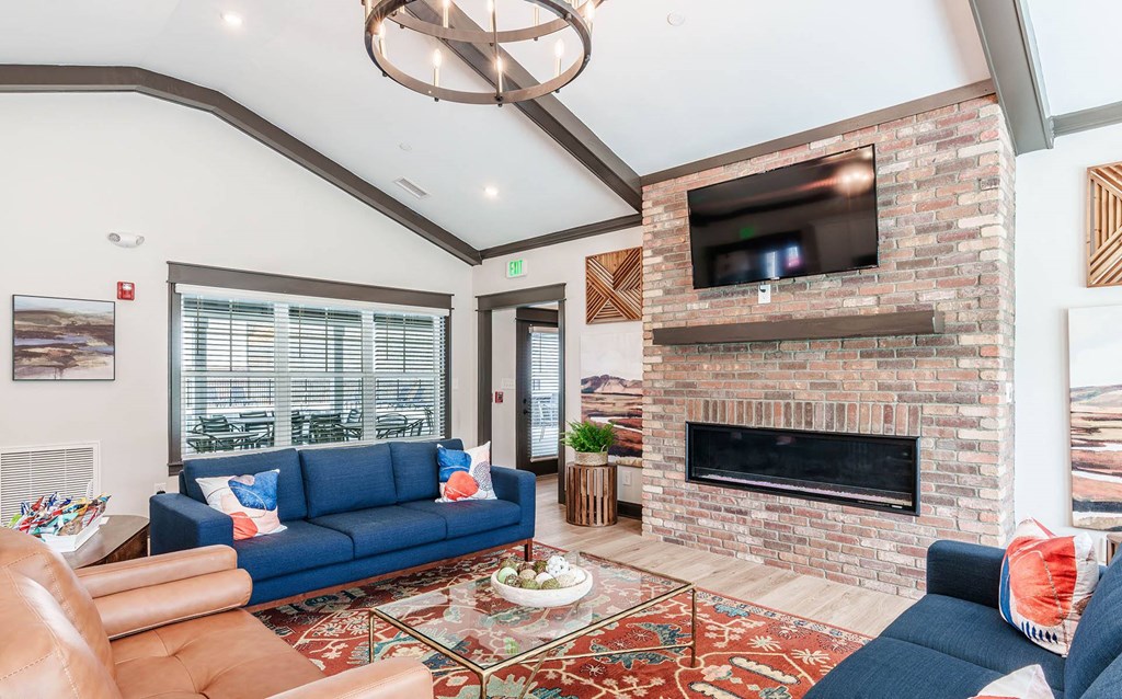 the living room has a large brick fireplace and a blue couch