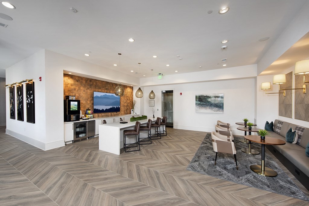 a communal area with tables and chairs and a bar in a lobby