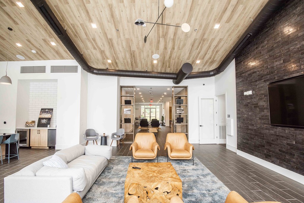 A modern living room with a white sofa and wooden ceiling.