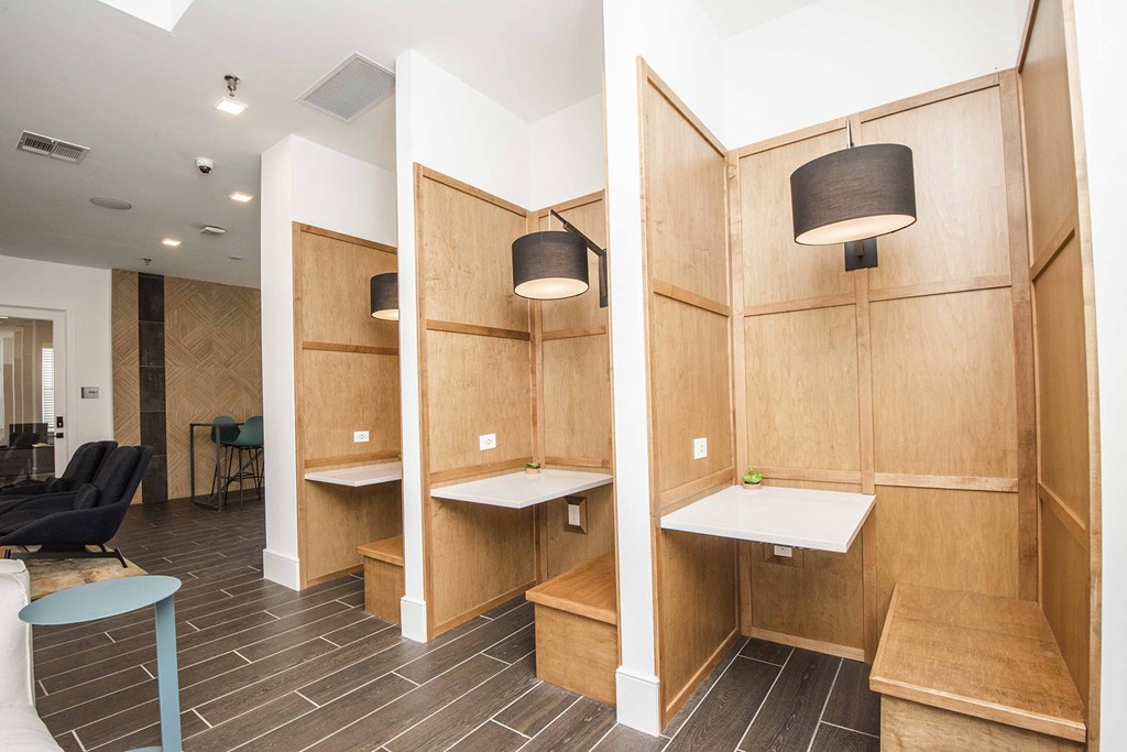 A room with wooden cubicles and a black chair.