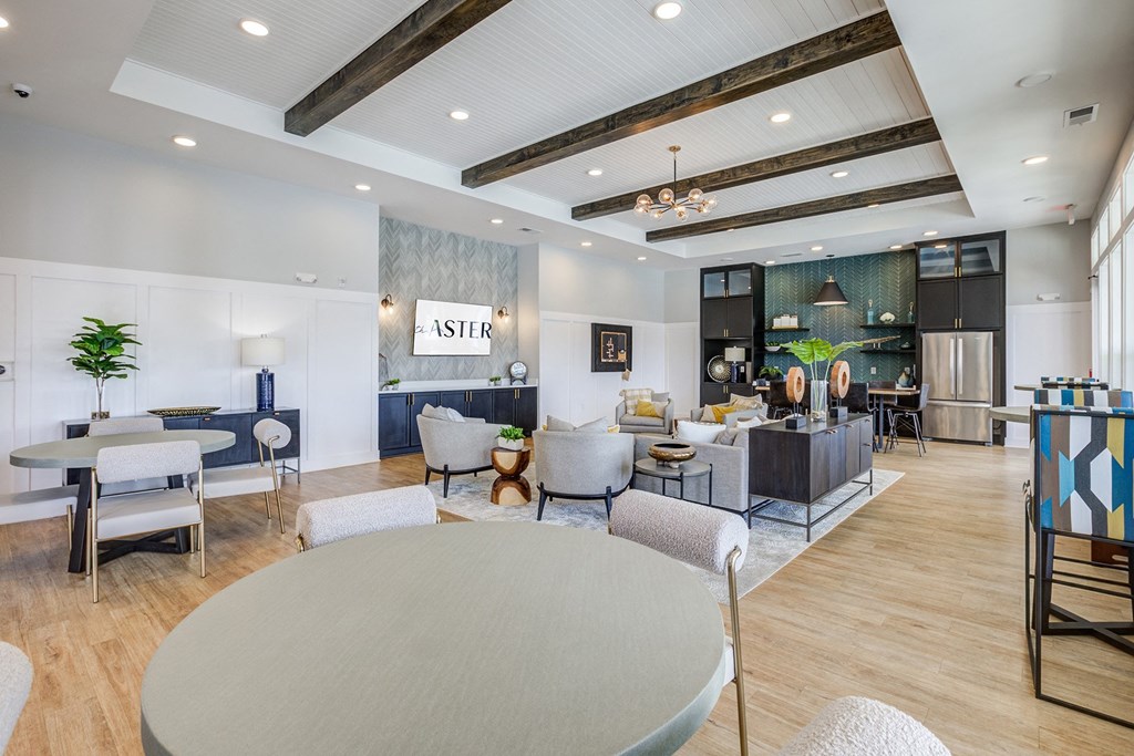 a large lobby with tables and chairs and a reception area