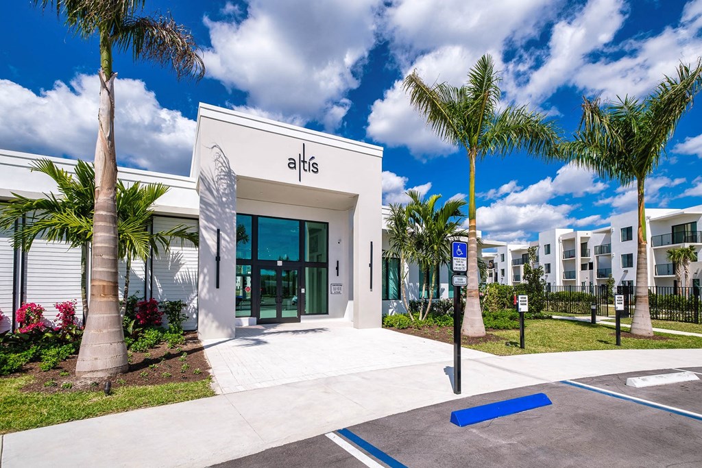 the leasing office at alis apartments building with palm trees at Altis Blue Lake, Lake Worth, FL, 33467