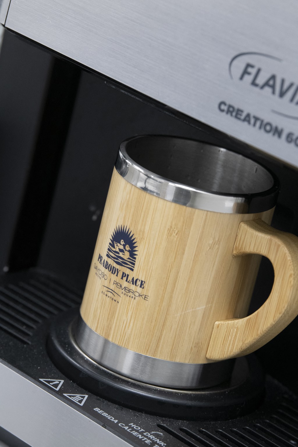 a coffee mug with the hull plate logo on a coffee maker