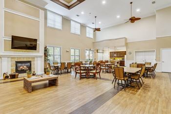 a large living room with tables and chairs and a fireplace