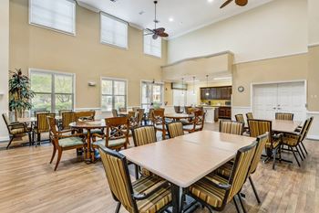 a large dining room with tables and chairs and a kitchen