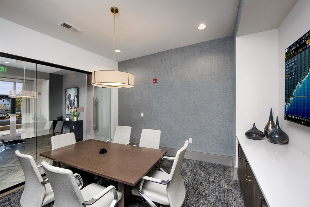 a conference room with a wooden table and white chairs