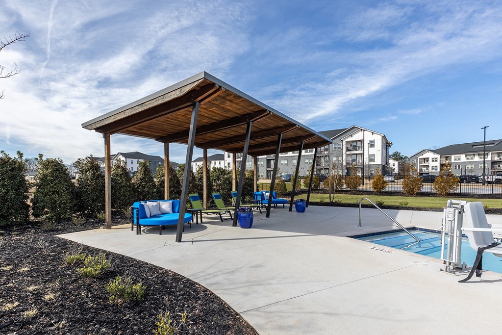 a canopy over a playground with a pool and chairs