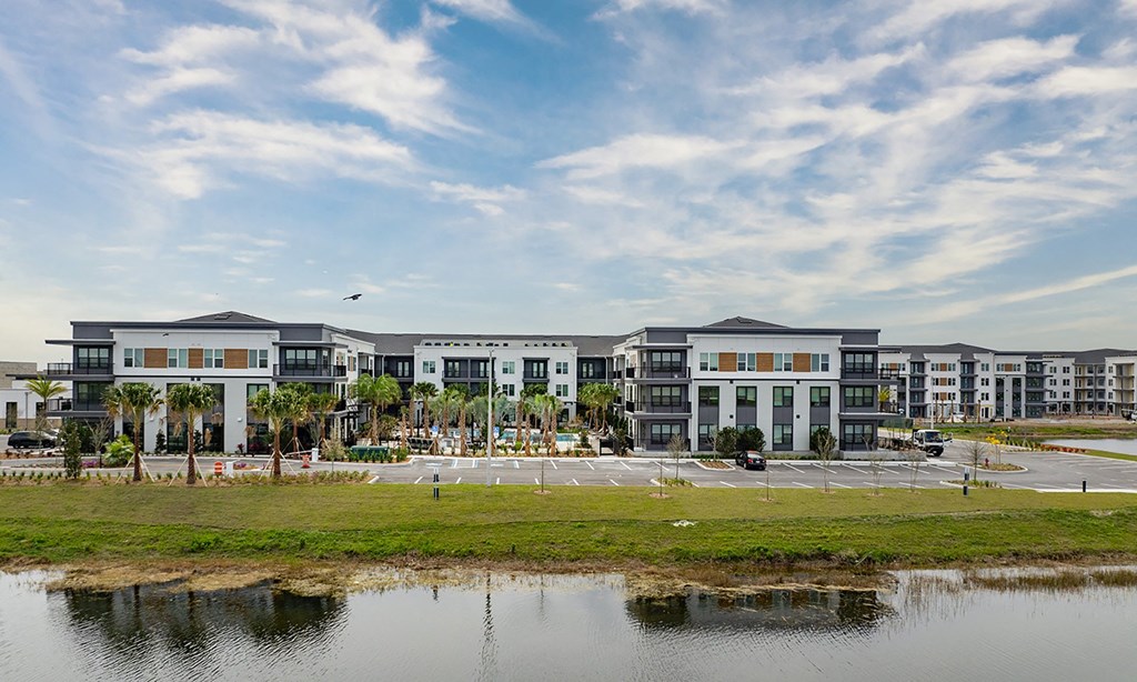 a large building with a parking lot and a body of water in apollo beach, florida