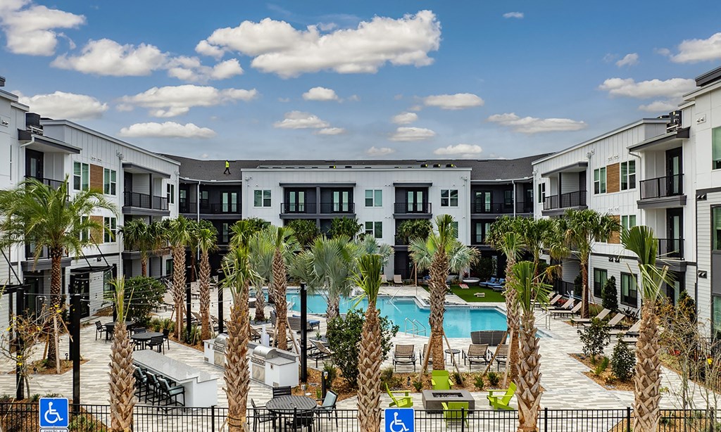 an apartment complex with a swimming pool and palm trees