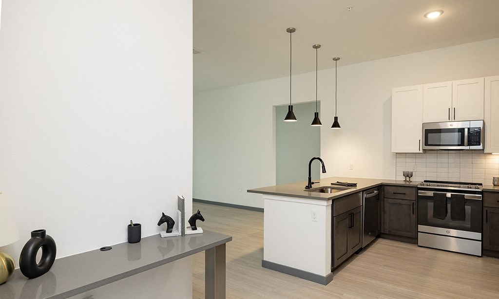 Modern kitchen in a Florida apartment featuring an island, stove, and microwave.