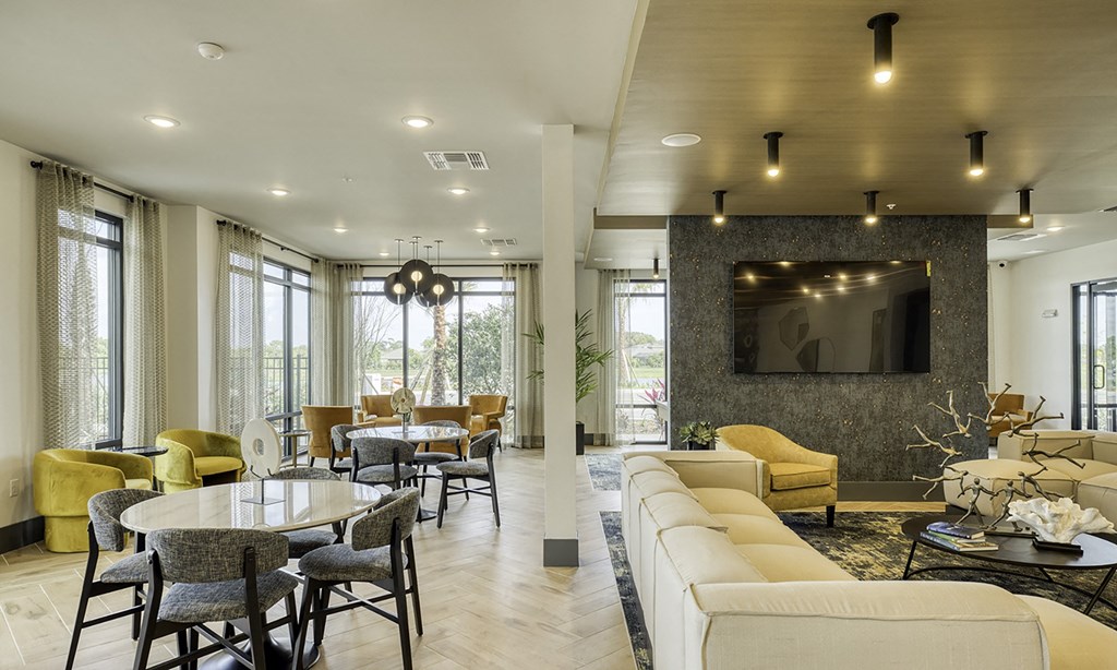a living room with yellow couches and tables and a large window in apollo beach, florida