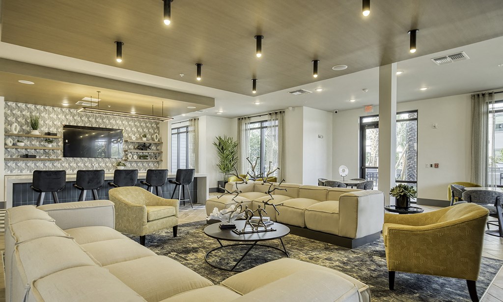 a large living room with couches and chairs and a bar in apollo beach, florida