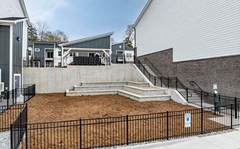 the yards are fenced in with stairs and a patio