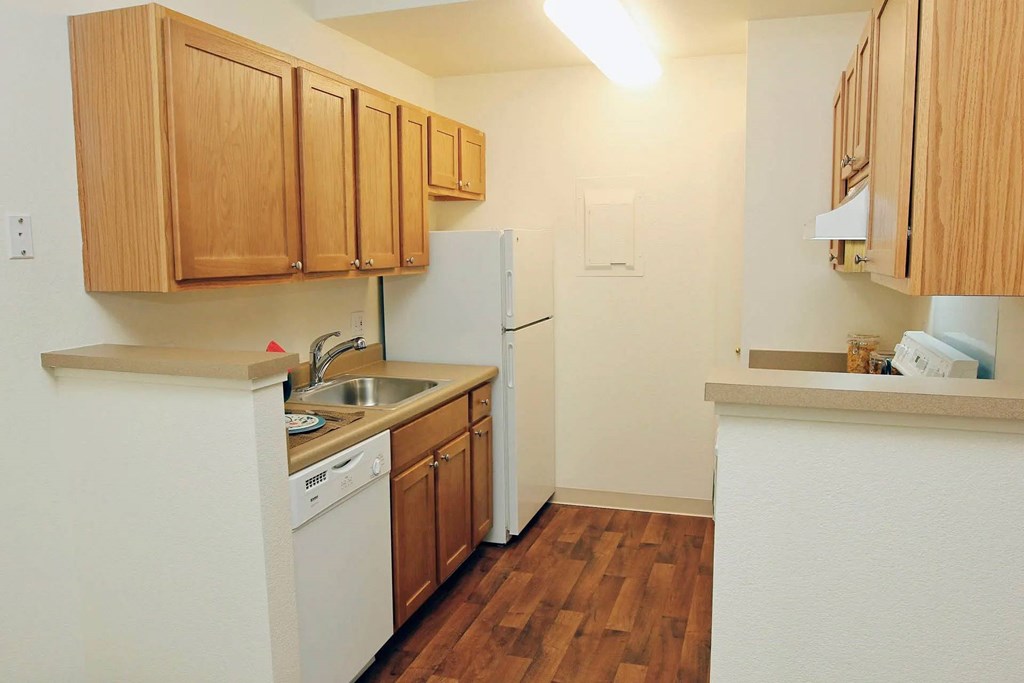 A kitchen with wooden cabinets and white appliances.