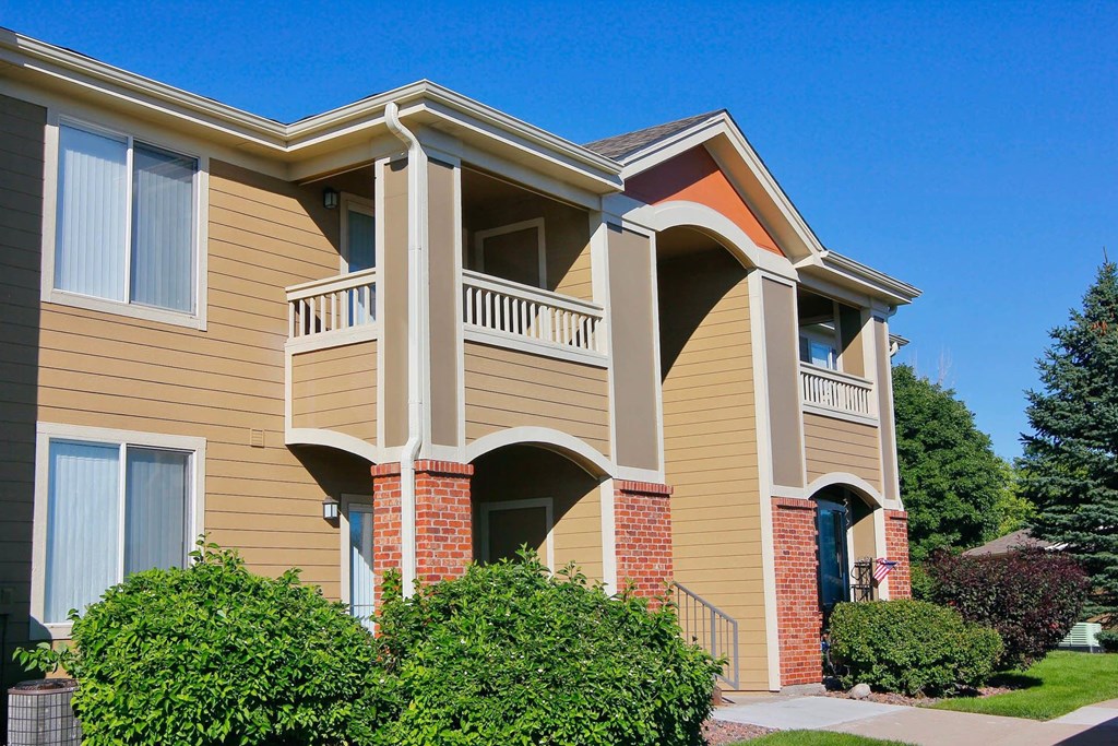 A two-story apartment building with a balcony on the second floor.