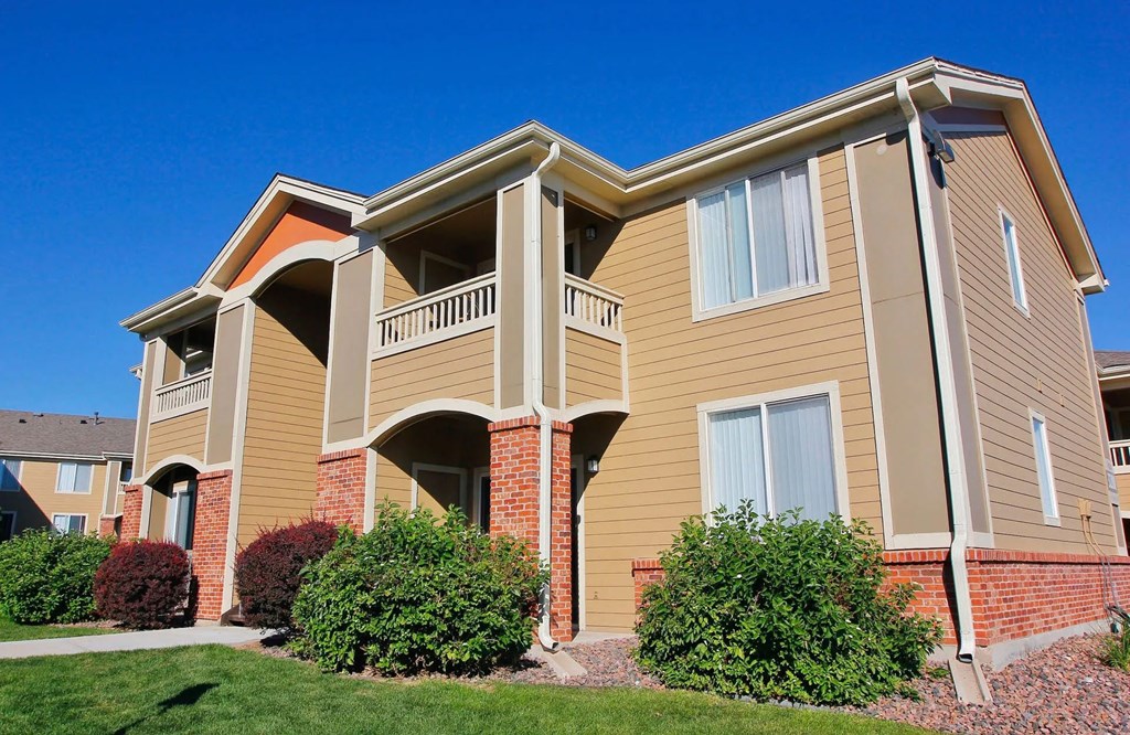 A large two-story apartment building with a balcony on the second floor.