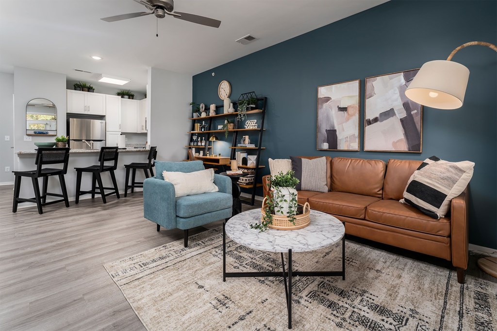 A living room with a blue chair, a brown couch, and a coffee table.