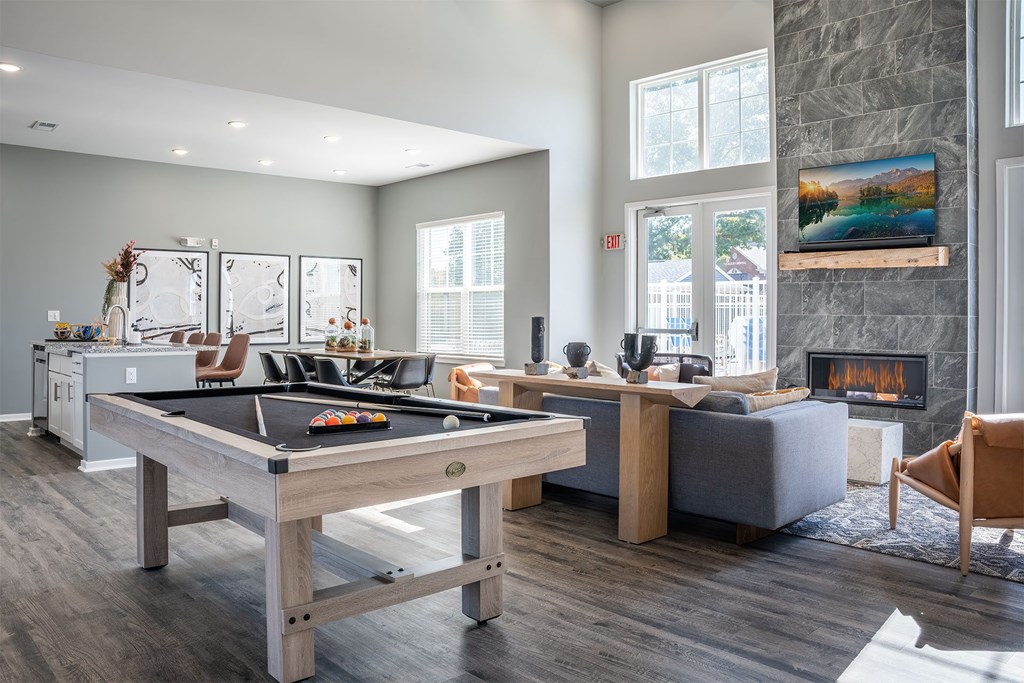 A room with a pool table and a fireplace.