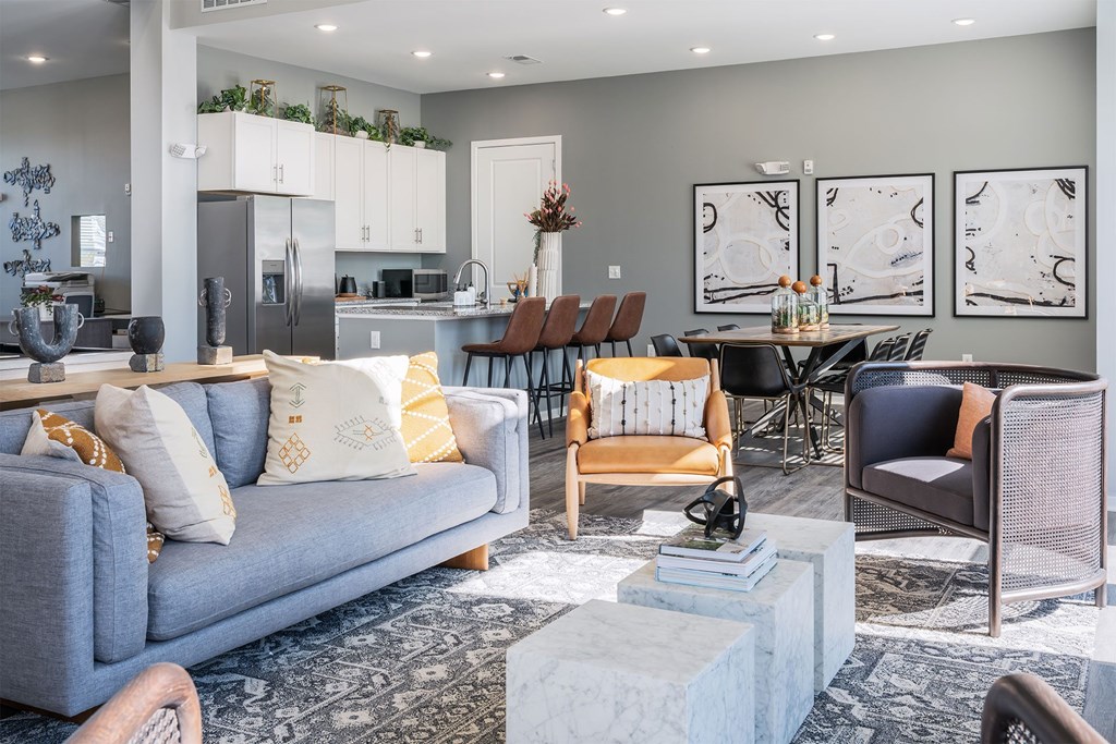 A modern living room with a grey sofa and a dining table set up.