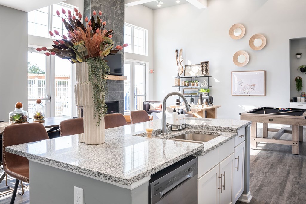 A kitchen with a marble countertop and a vase of flowers on it.