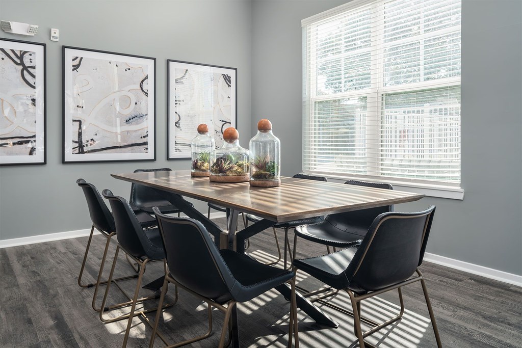 A dining table with chairs and a bottle of water on it.