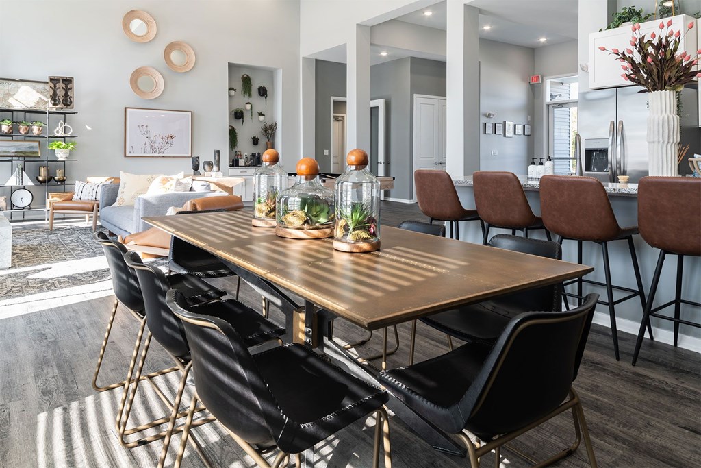 A modern dining room with a wooden table and black chairs.