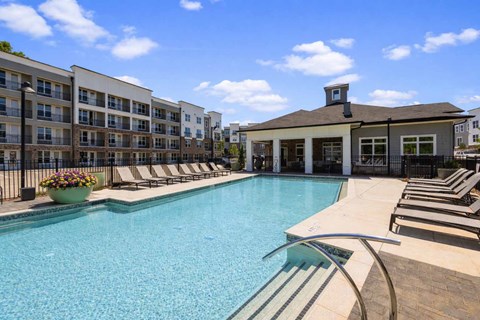 A large swimming pool with a building in the background.