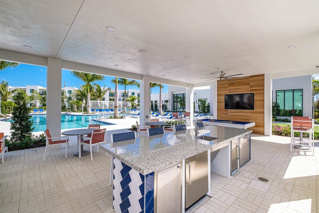 a kitchen with a bar and a view of a pool at Altis Blue Lake, Lake Worth, Florida