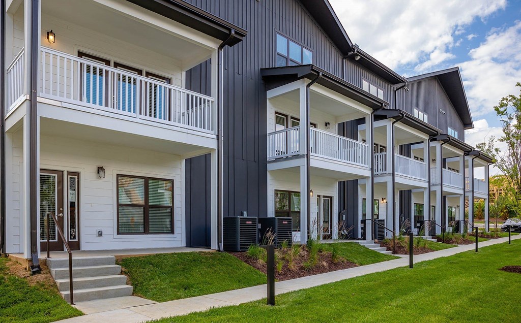 a row of houses with steps and grass in front of them