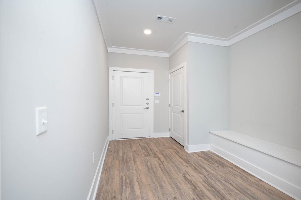 a renovated living room with white walls and wood floors