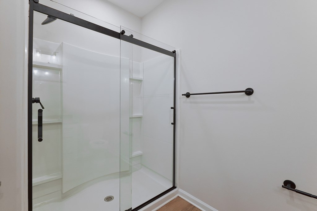 A white bathroom with a glass shower door.