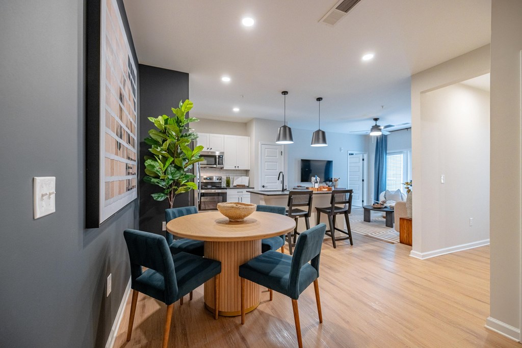 A modern dining room with a round table and chairs.