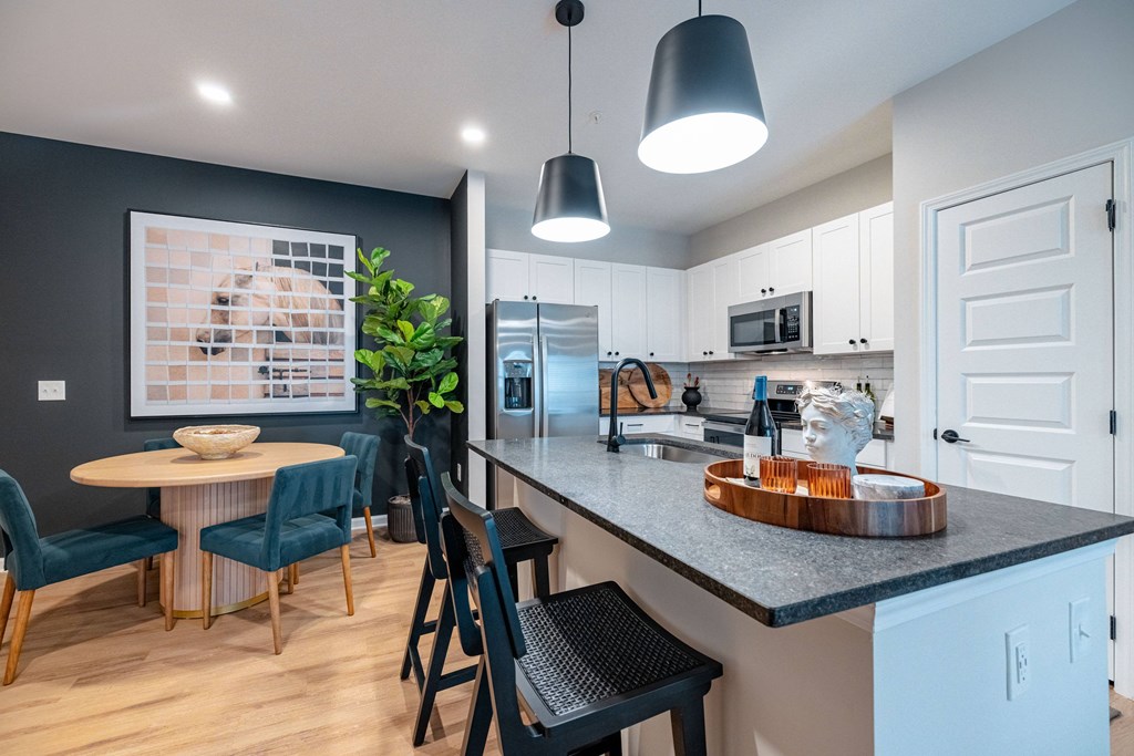 A kitchen with a table and chairs.