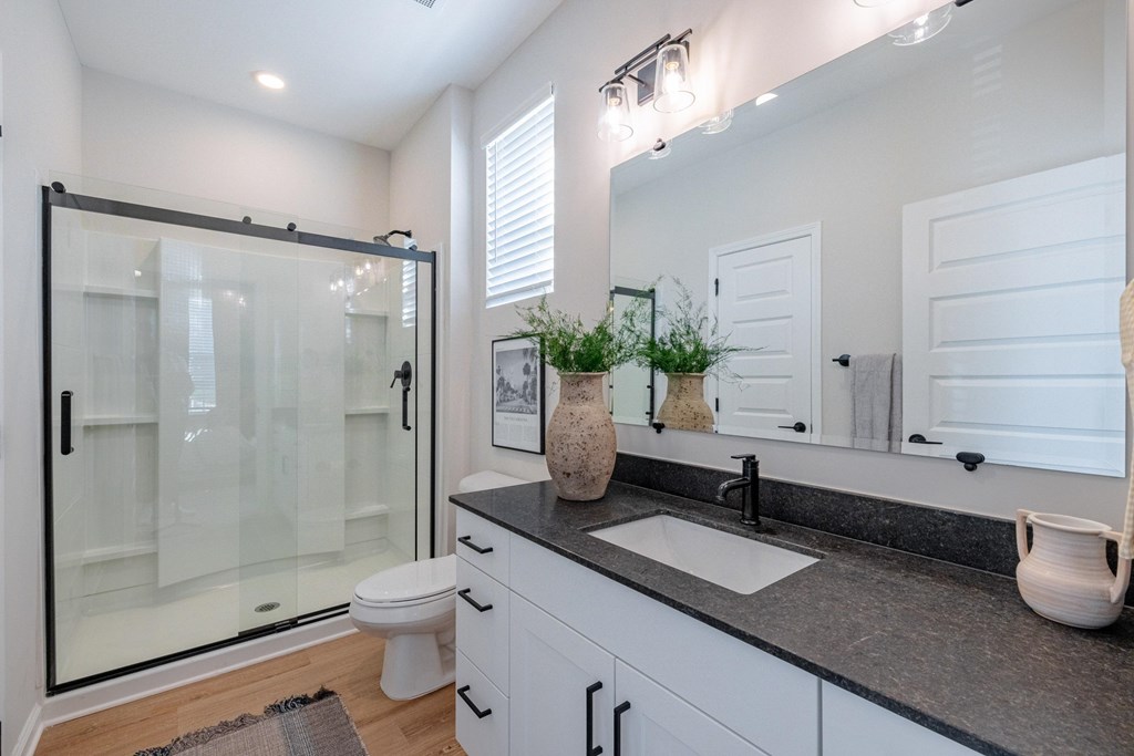 A bathroom with a black countertop and a white toilet.