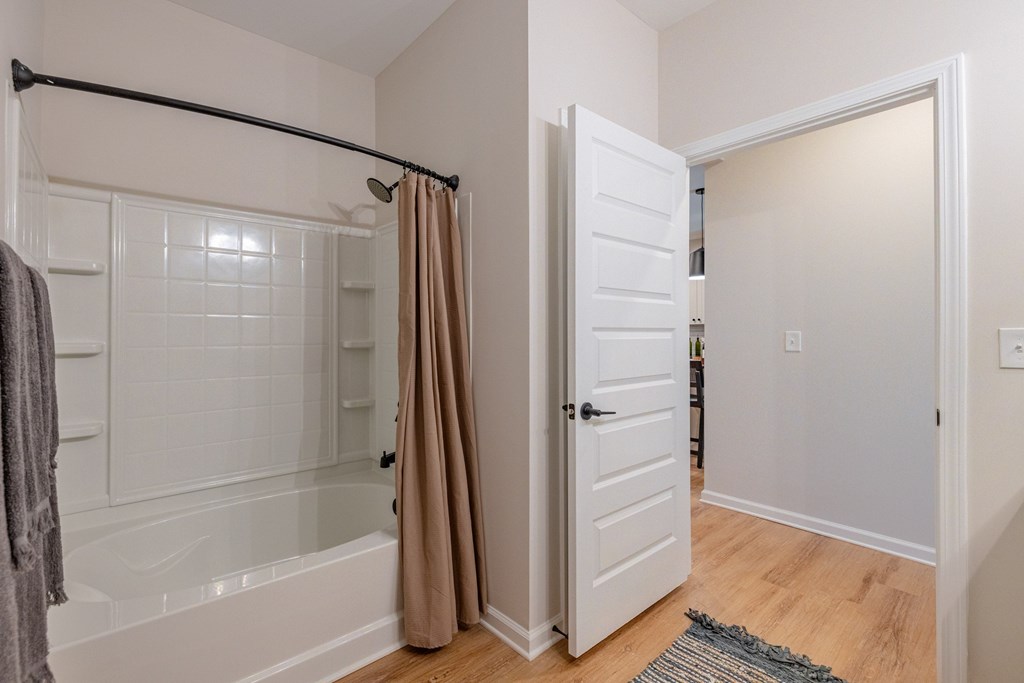A bathroom with a white tub and a white door.