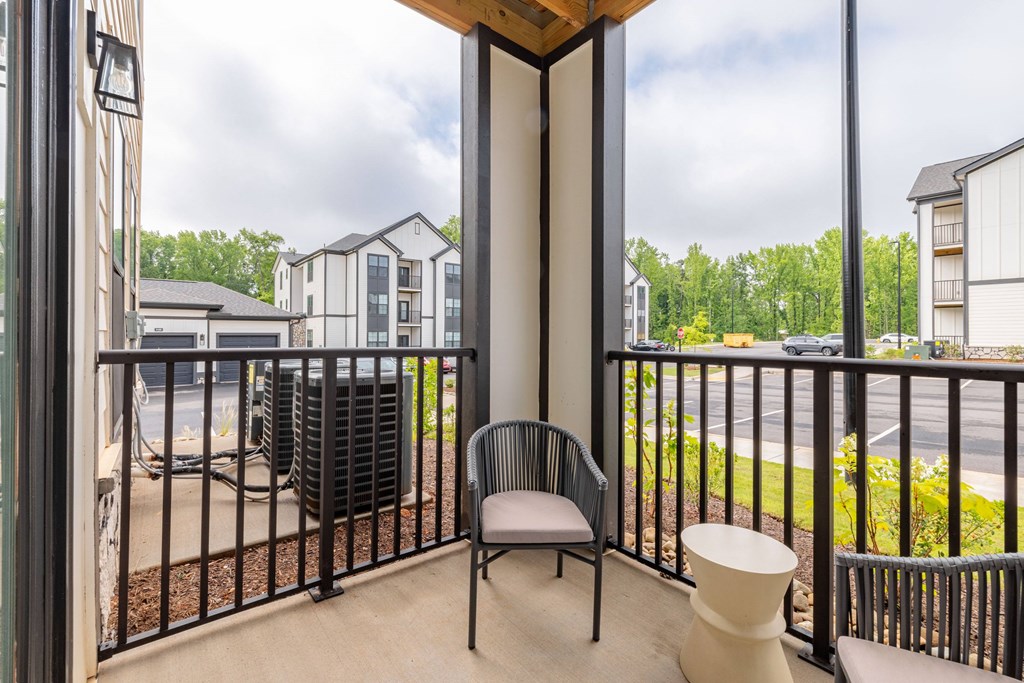 A balcony with a chair and a table.