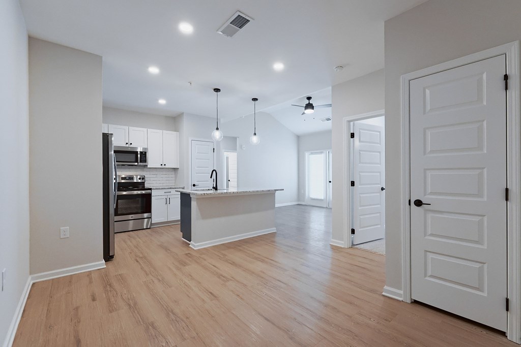 A kitchen with a refrigerator, oven, and microwave.