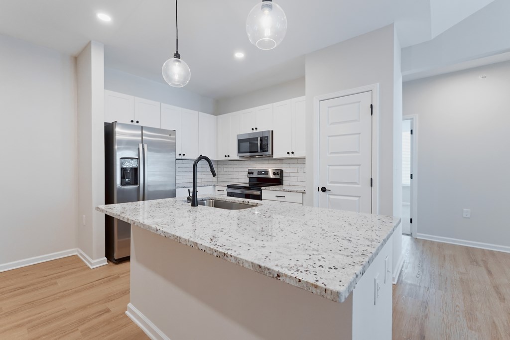 A kitchen with a granite countertop and stainless steel appliances.
