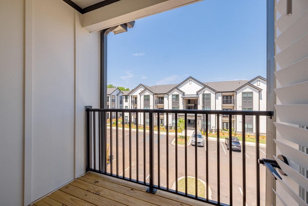 A balcony with a view of a street and houses.