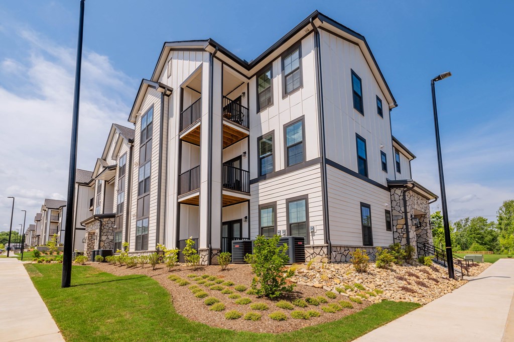 A modern two-story apartment building with a well-maintained lawn in front.