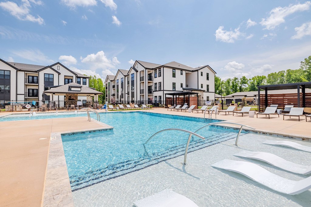 A large swimming pool in front of apartment buildings.